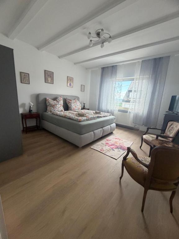 a living room with a bed and a chair at Ferienwohnung Kirschtraum in Mülheim-Kärlich