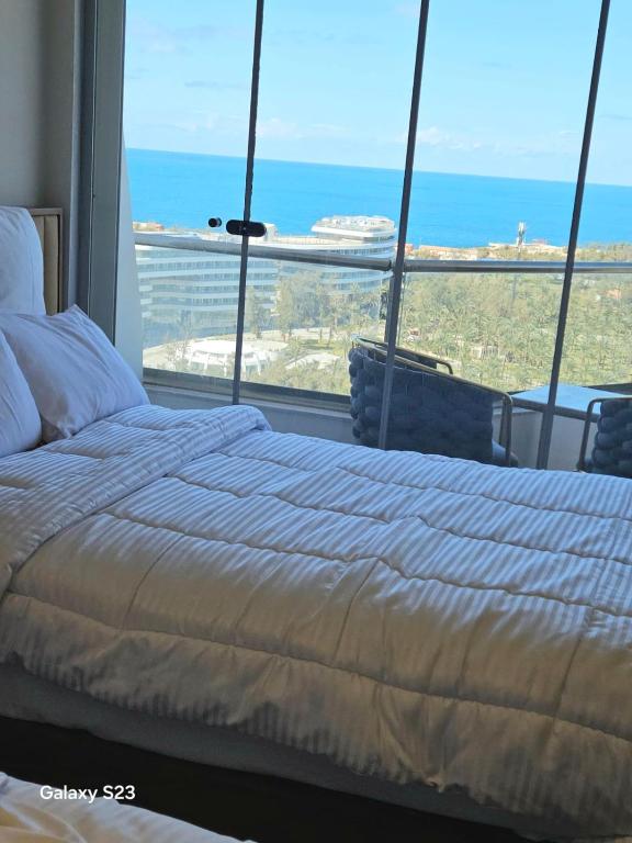 a bed in a room with a view of the ocean at Sheraton Royal Sea View in Alexandria