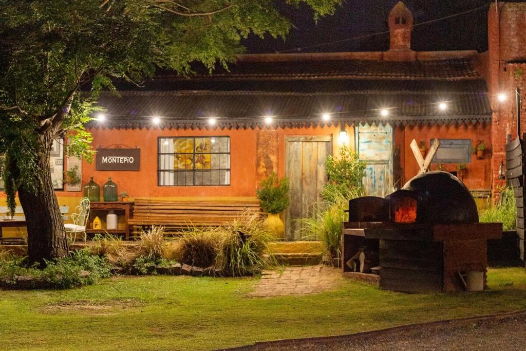 a house with an outdoor fireplace in a yard at night at casa montepio in San Antonio de Areco