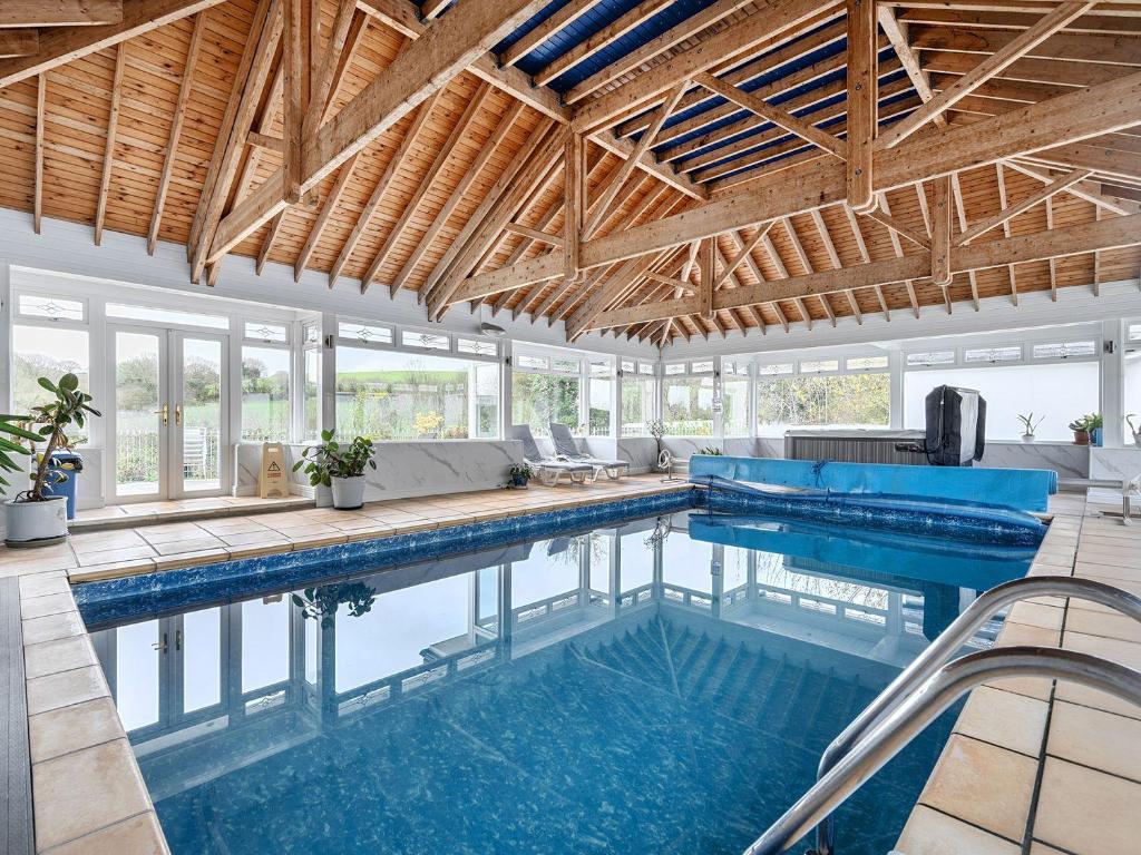 an indoor swimming pool with a couch and a table at Chapel Green Studio in St Austell