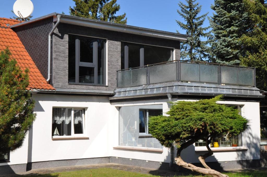 a white house with a balcony on top of it at Ferienunterkunft Grüner Weg in Ueckermünde