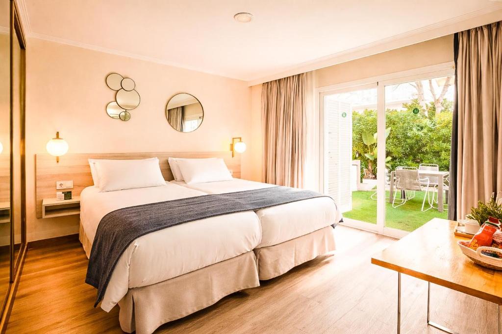 a hotel room with a bed and a large window at Nura Houses Condor in Playa de Palma