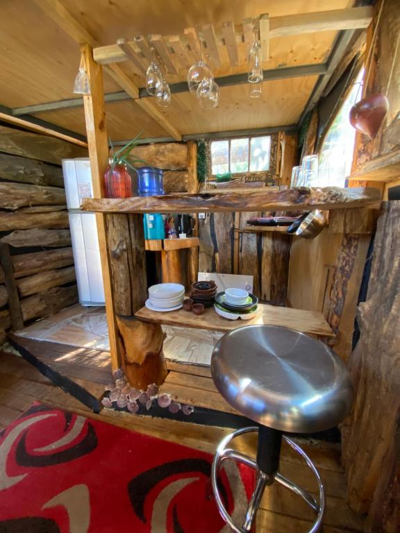 ein Zimmer mit einem Barhocker in einer Hütte in der Unterkunft Barbablancaspa in San José de Maipo