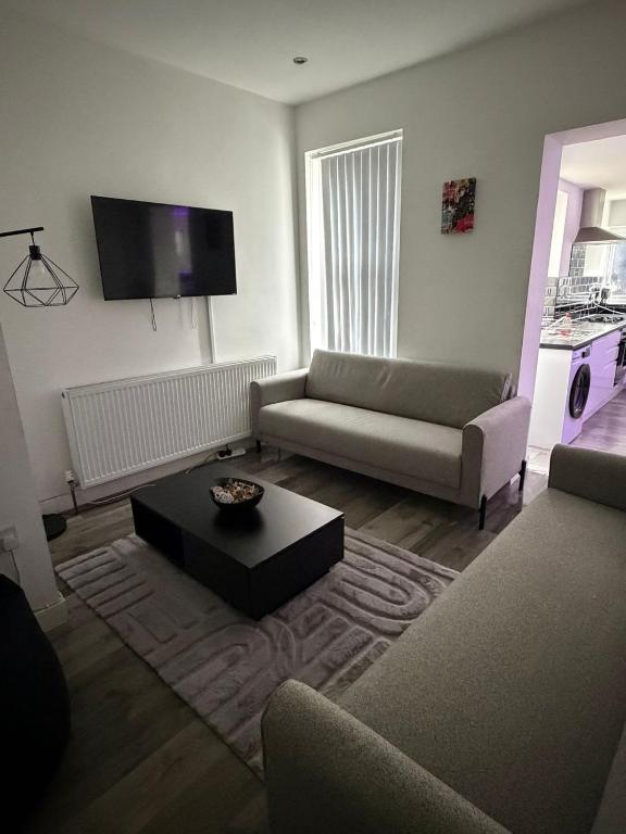 a living room with a couch and a coffee table at Large 6 Bed 6 Bathroom House - Ideal For Families, Large Groups, Contractors & Business Travellers in Watford