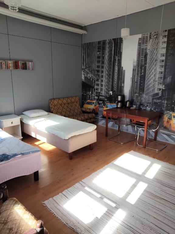 a room with two beds and a desk and a couch at Willa Witsari 27m2 in Kokkola