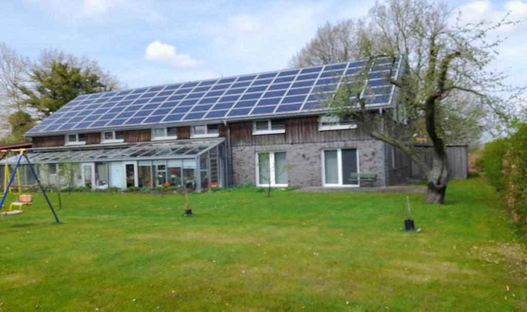 a house with a lot of solar panels on the roof at Franzenhof Beldorf in Beldorf