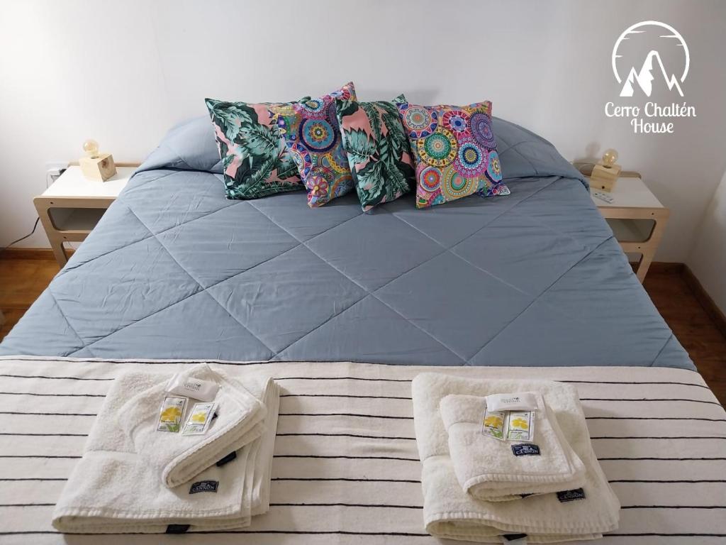 a bedroom with a bed with towels on it at Cerro Chaltén House - Deptos in El Chalten