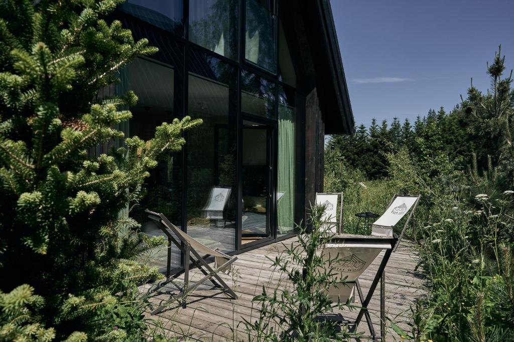 a house with two benches on a patio at Chalets by Slow Tatry Boutique Resort&SPA in Zakopane