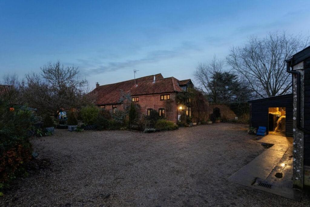 a large house with a driveway in front of it at Roundabout Farm in Thurning