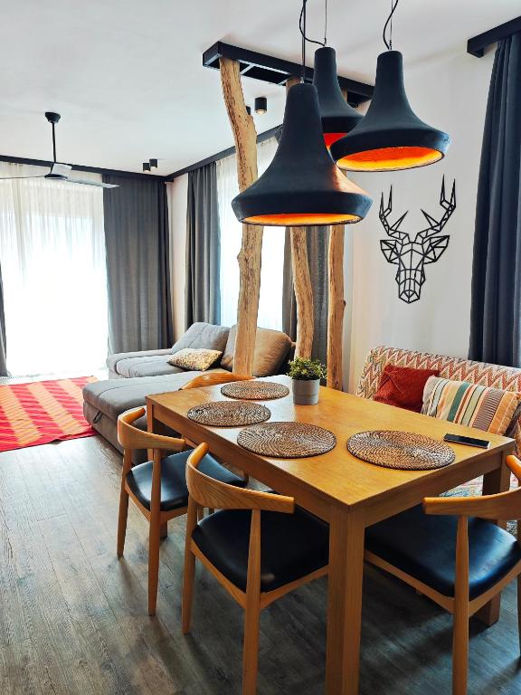 a living room with a wooden table and chairs at DOR Apartment in Poiana Brasov
