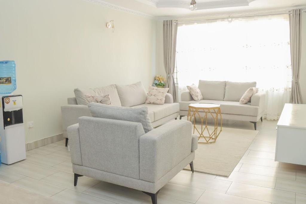 a living room with two chairs and a couch and a table at D&H Homes Milimani Nakuru-Elegant 2 Bedroom Apartment in Nakuru