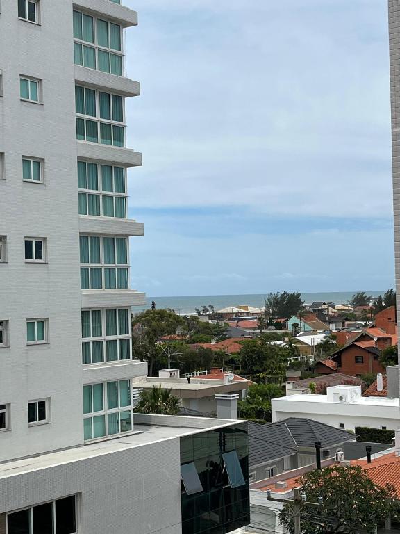 a tall building with a view of a city at Apartamento Completo Duas Quadras do Mar in Capão da Canoa