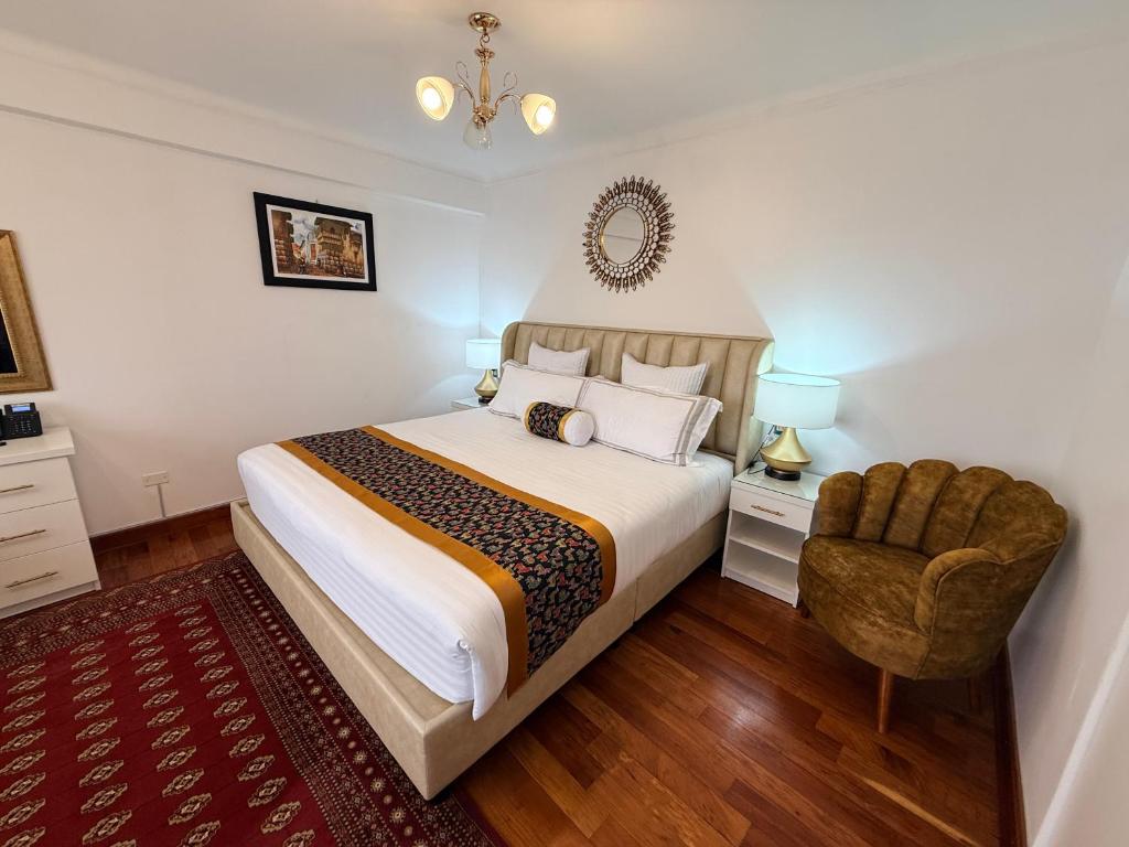 a bedroom with a large bed and a chair at Hotel-Apartment INKASABIOS in Cusco