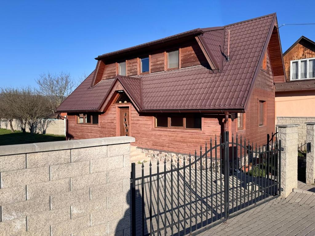a house with a brown roof and a fence at Chalupa u Jožka in Betlanovce