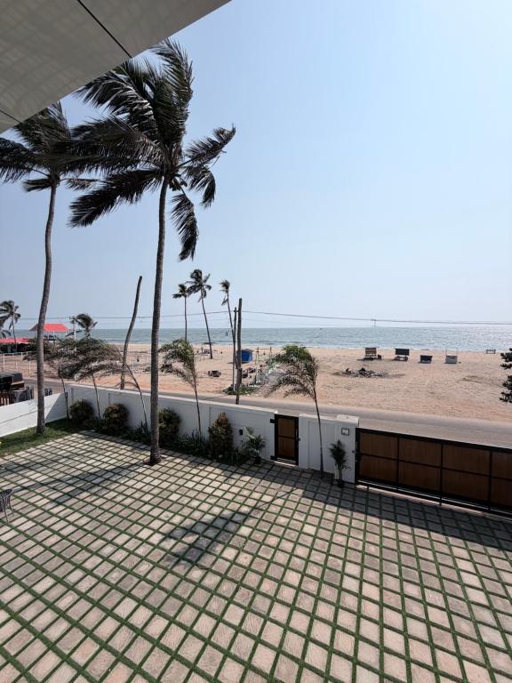a balcony with a view of the beach at LAGUNA BLU beach villa in Irimbranallūr