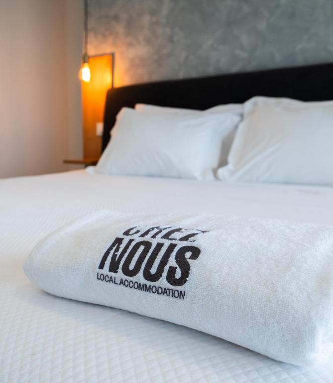 a bed with a white pillow with the words myosocalociation at Chez Nous I e II in Caloura