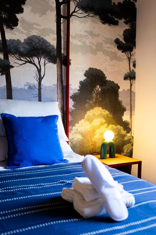 a bed with blue sheets and white towels on it at Luce sul Duomo in Tivoli