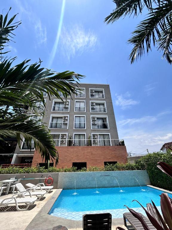 a hotel with a swimming pool in front of a building at Hotel Macaw Cúcuta in Cúcuta