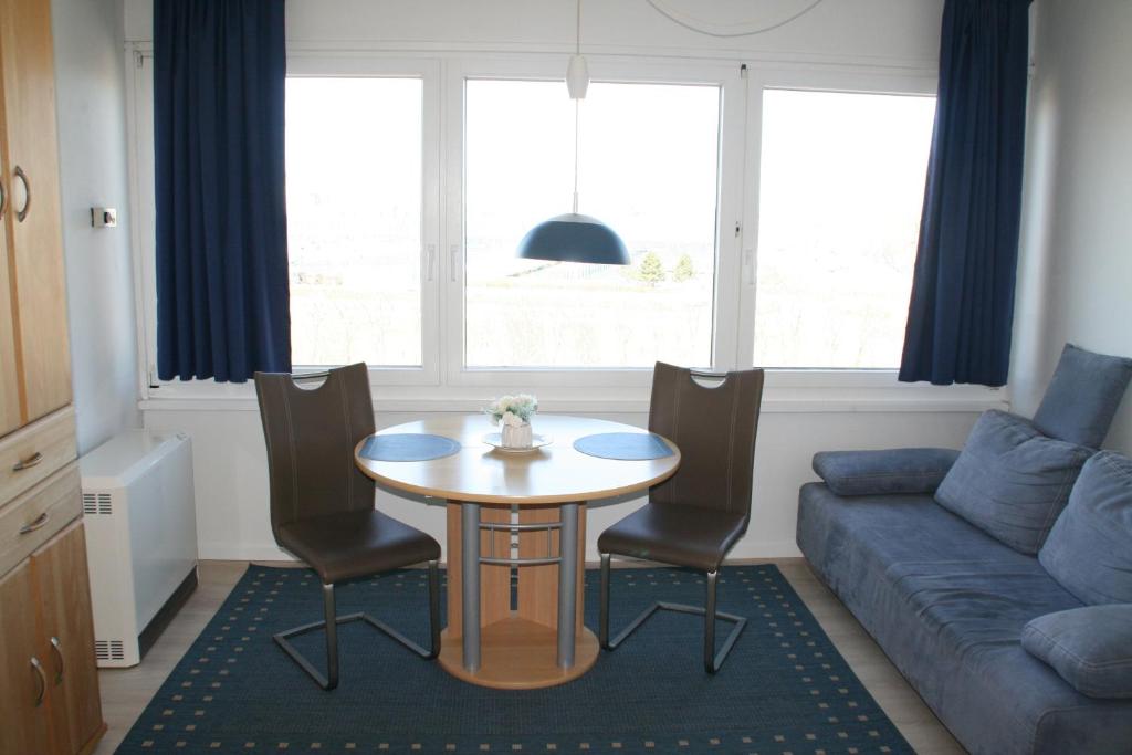 a living room with a table and chairs and a couch at FW Knütel Nr 59 in Burgtiefe auf Fehmarn 