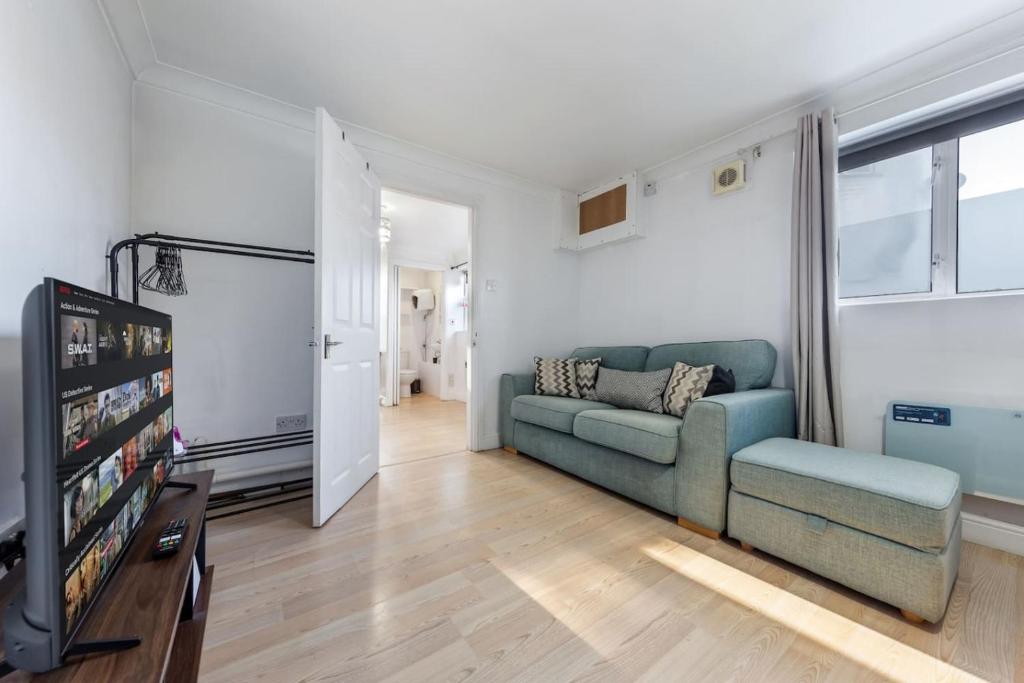 a living room with a couch and a tv at Private Annex with Gated Driveway near Grove Park Station in Hither Green