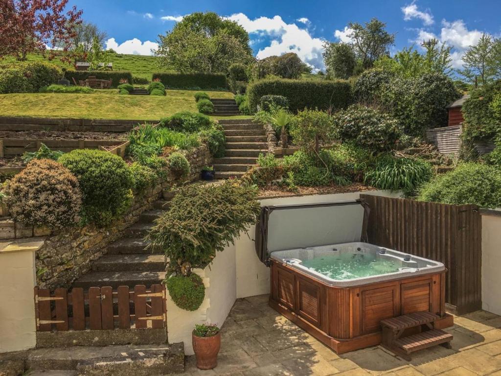 a hot tub in a garden with stairs at 4 Bed in Bridport oc-dc195 in Loders