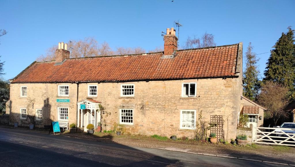 an old brick building with a red roof at Coxwold Tearoom in Coxwold