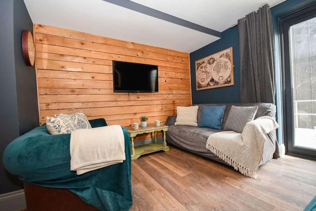 a living room with a couch and a flat screen tv at 2 Private Rooms in Shared Apartment with Kitchen in Leeds