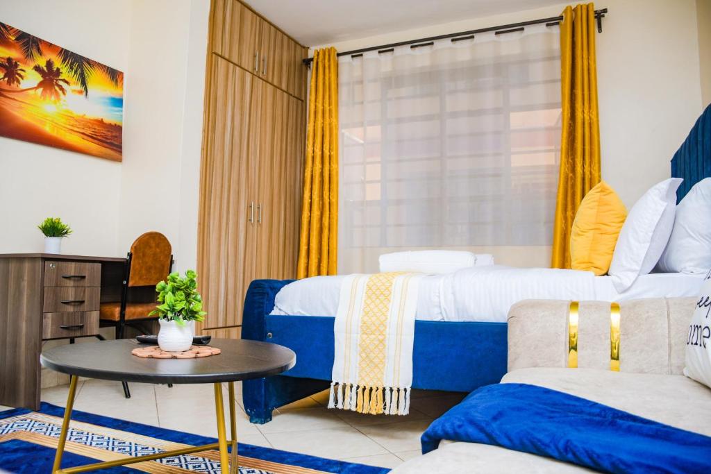 a hotel room with two beds and a table at lexy homes in Ruiru