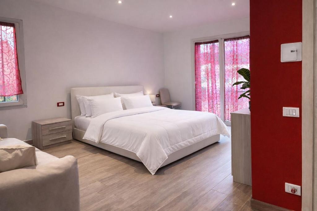 a bedroom with a large white bed and two windows at Arvén Crimson in Marghera