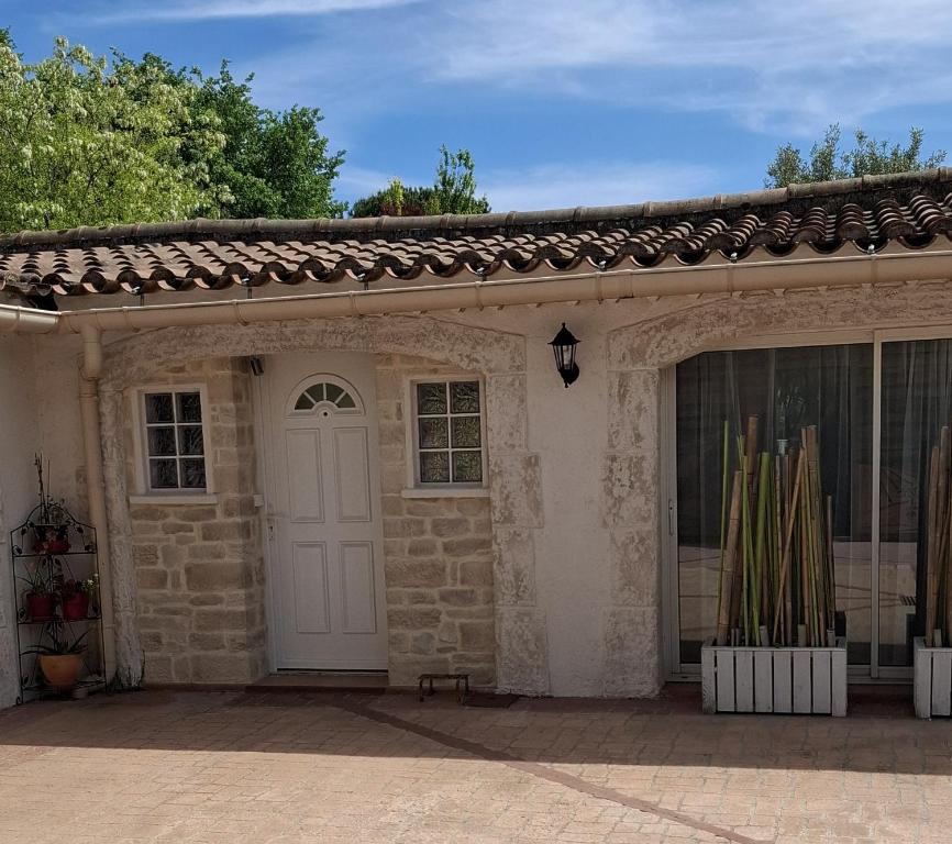 a stone house with a white door and windows at Carabas84 in Carpentras