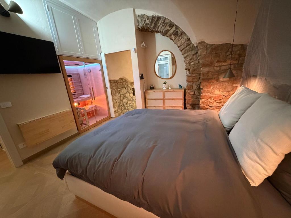 a bedroom with a large bed and a stone wall at Casa Vacanza Zhurian in Ginestra