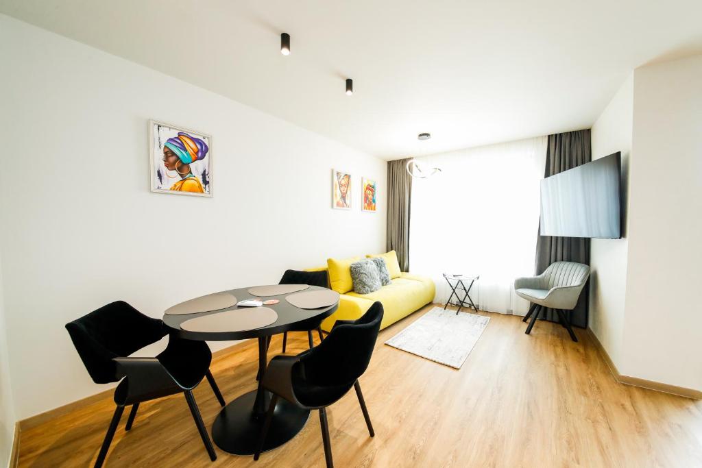 a living room with a yellow couch and a table at Еlite central stay apartment in Pleven