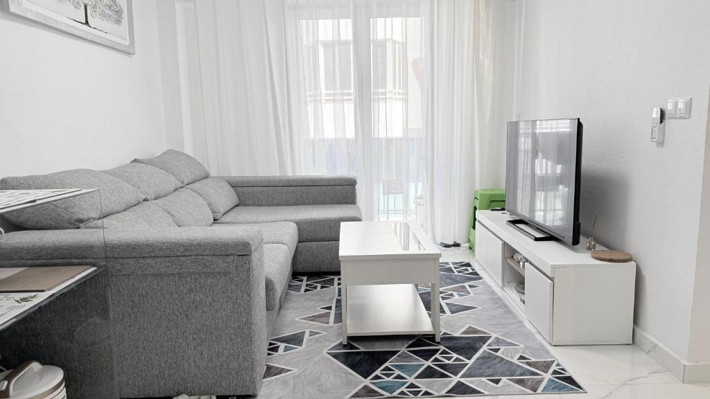 a living room with a couch and a tv at Caballero in Torrevieja