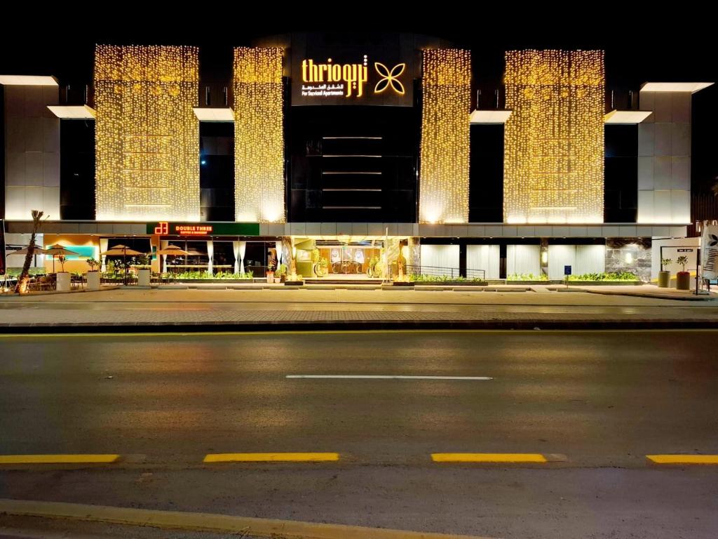 an empty street in front of a building at night at ثريو thrio للشقق المخدومة in Riyadh