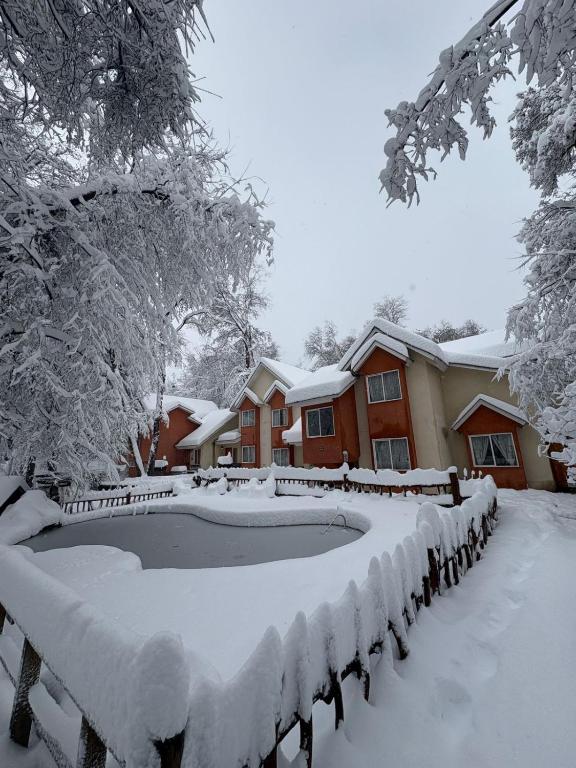 a house with a swimming pool covered in snow at Hotel y Cabañas Borde Andino in Las Trancas