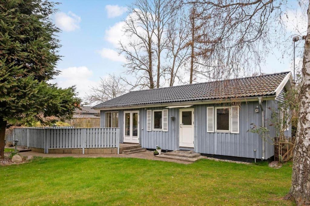 a small blue house in a yard at S745-Stroby-Garderhojen-35 in Strøby