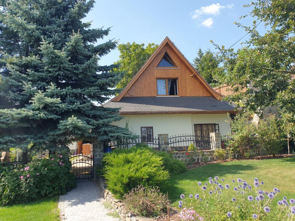a house with a gambrel roof and a garden at Chalupa 58 in Štiavnické Bane