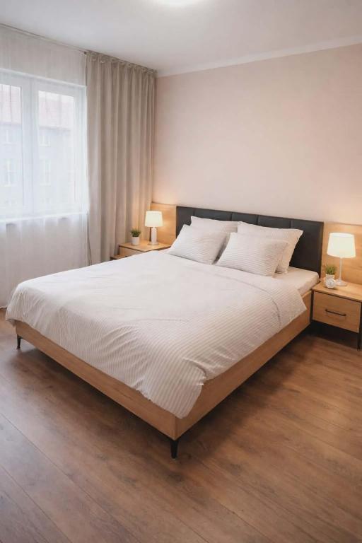 a bedroom with a large white bed with two lamps at Krakowski in Boguszów-Gorce