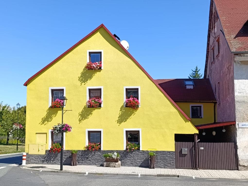 a yellow house with flower boxes on it at Vybavený byt in Krásno