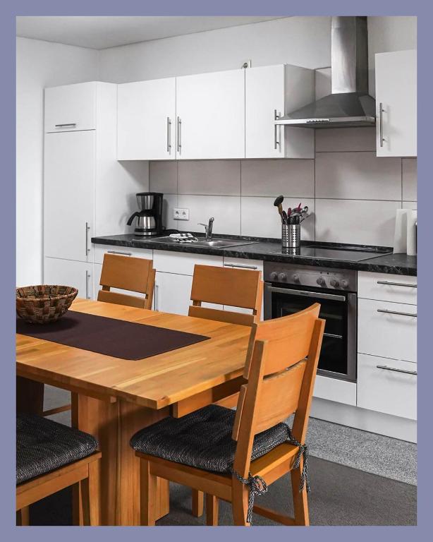 a kitchen with a wooden table and chairs at Schwarzwaldpension Tuttlingen in Tuttlingen