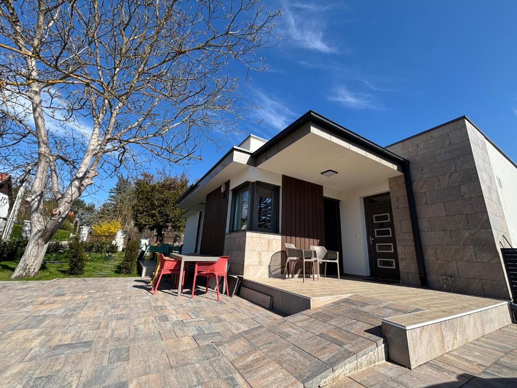 a house with a table and chairs on a patio at KutyaGazdi Apartman in Balatonfenyves