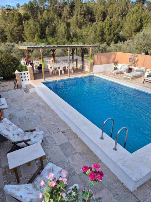 a swimming pool in a backyard with chairs and flowers at beautiful guest room with swimming pool in Gormach