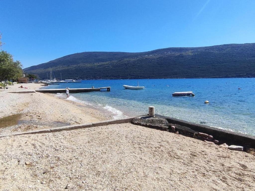 a beach with some boats in the water at Apartments Skipper bay Kumbor in Herceg-Novi