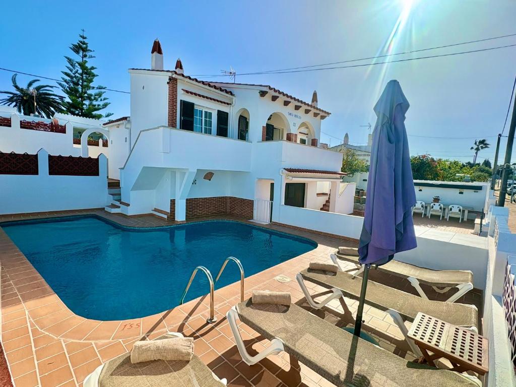 a villa with a swimming pool in front of a house at Santa Brígida in Cala en Porter