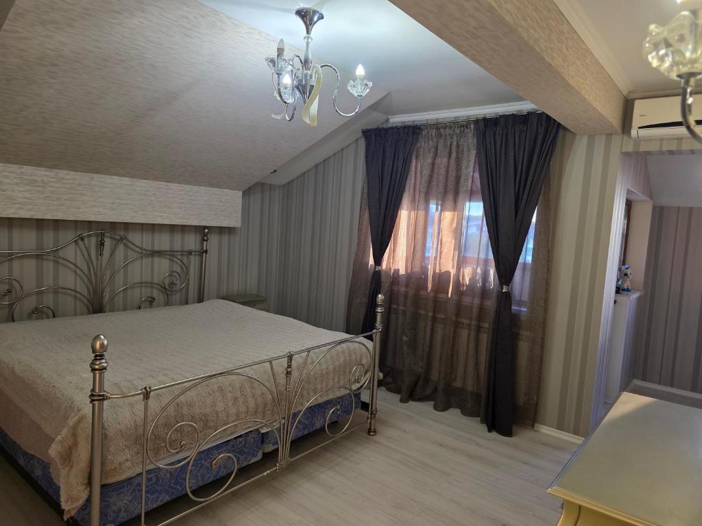 a bedroom with a bed and a chandelier at Boutique Apartment with Jacuzzi Pleven in Pleven