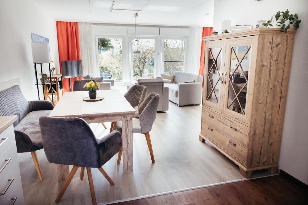 a living room with a table and chairs and a cabinet at Casa La Vie Ferienwohnungen in Altenstadt
