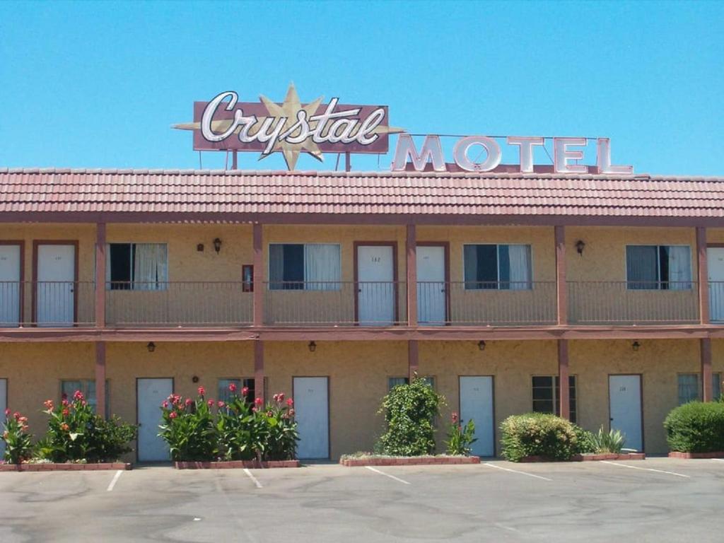 a hotel with a sign on top of it at Crystal Motel in Red Bluff