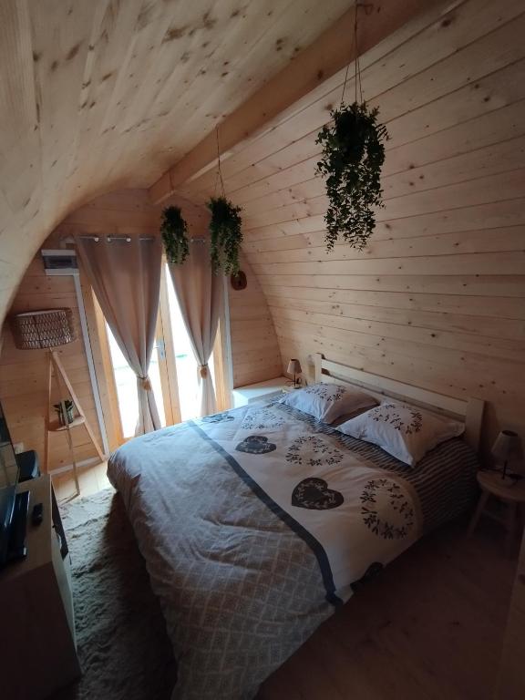 a bedroom with a bed in a log cabin at Au petit chalet in Meisenthal