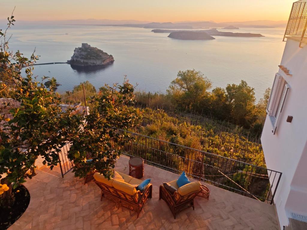 a balcony with chairs and a view of the ocean at Campagnano Rural Suite & Spa in Ischia Town