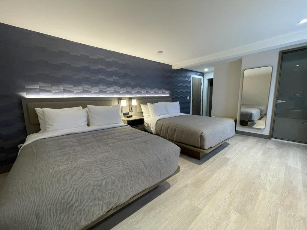 a hotel room with two beds and a mirror at Le Grand Hotel St-Georges in Saint-Georges